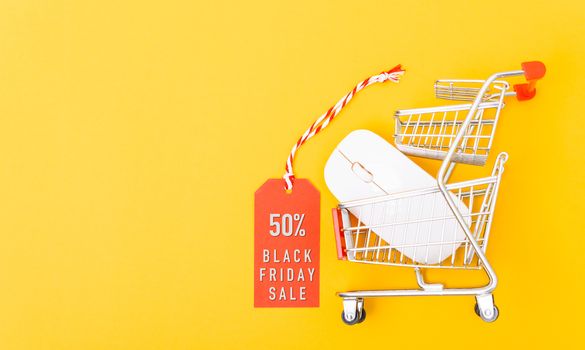 Online shopping Black Friday sale text on red tag label have white mouse on cart shopping, with copy space on yellow background