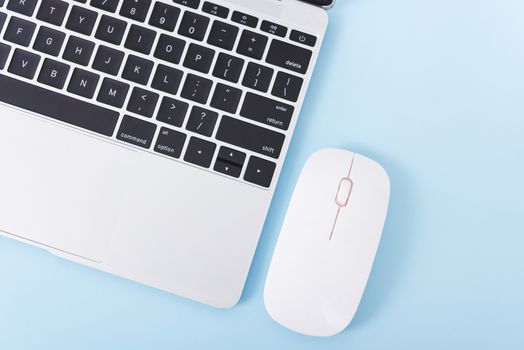 Top view laptop computer notebook and wireless mouse isolated on blue background