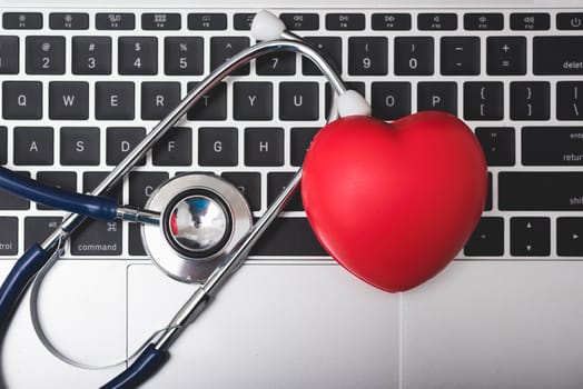 Health stethoscope and red heart on keyboard of laptop computer, medical concept