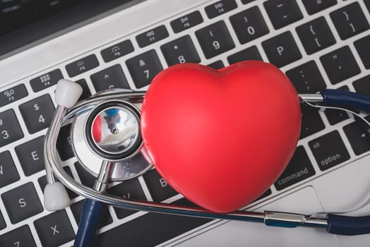 Health stethoscope and red heart on keyboard of laptop computer, medical concept