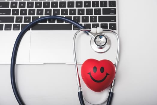 Health stethoscope and red heart on keyboard of laptop computer, medical concept