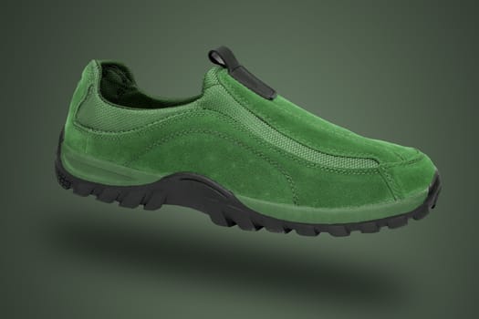 Green shoe on green background, isolated product.