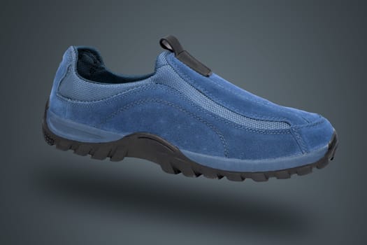 Blue shoe on blue background, isolated product.