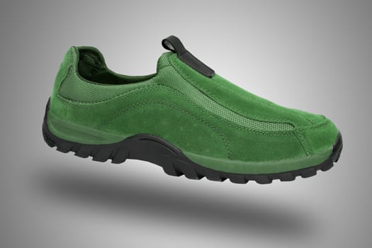 Green shoe on grey background, isolated product.