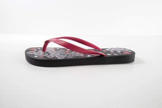 Black and pink rubber slipper on white background, isolated product.