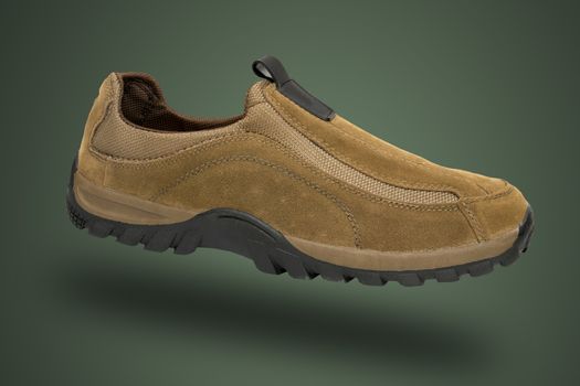 Male brown leather sneaker on green background, isolated product.