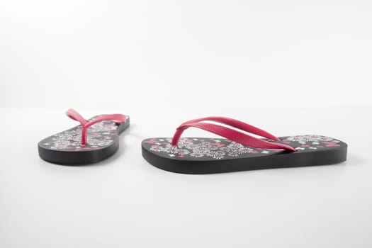 Black and pink rubber slipper on white background, isolated product.