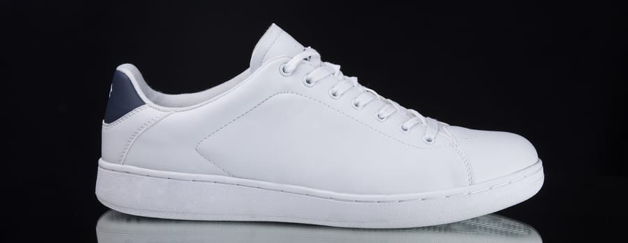 Male white sneaker on black background, isolated product.