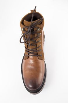 Brown leather boots on white background, isolated product, top view.