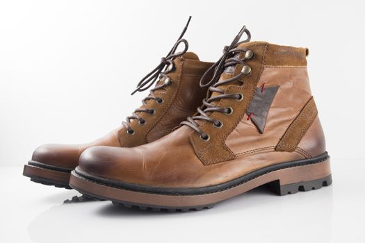 Pair of brown leather boots on white background, isolated product, top view.