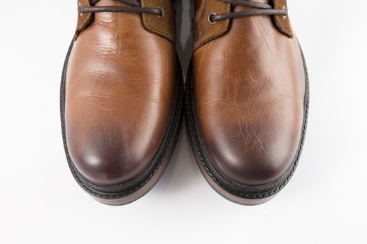 Pair of brown leather boots on white background, isolated product, top view.
