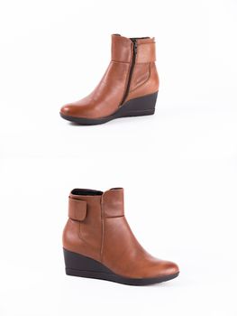 Pair of brown leather boots on white background, isolated product, top view.