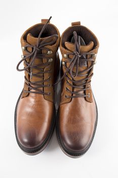 Pair of brown leather boots on white background, isolated product, top view.