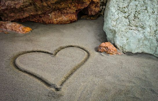A heart drawn on the sand of the unspoiled beach: a gesture of sweet and poetic love for those who truly love