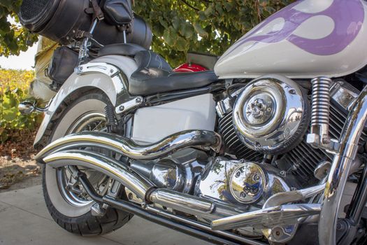 Custom motorcycle, detail of the engine and chrome in sight, with a beautiful natural background.