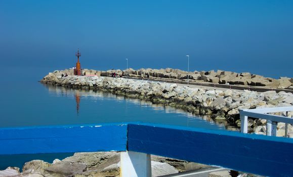 Heavenly view of the pier of the port of Giulianova in Abruzzo Italy. A mystical landscape in which the orrizzontre line between sky and sea merge into a unique spectacle.