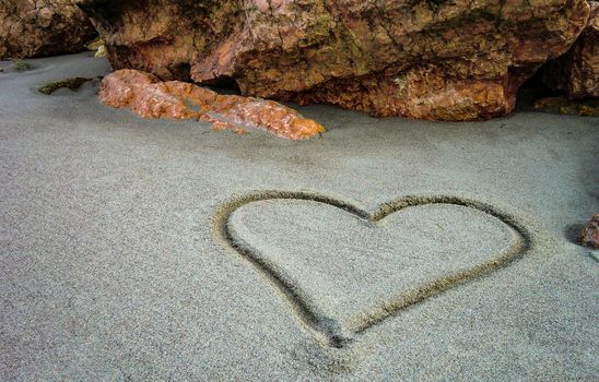 A heart drawn on the sand of the unspoiled beach: a gesture of sweet and poetic love for those who truly love