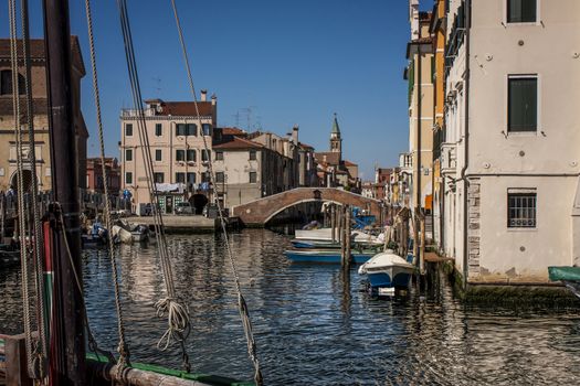 A typical landscape of Chioggia, Italian city in the Veneto lagoon near Venice. A bridge over water with half a multitude of boats of transport typical of this area ...
