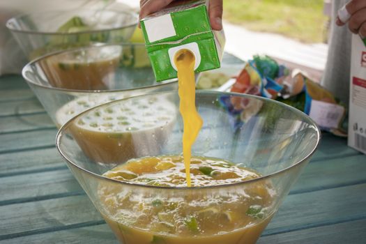 Pour fruit juice into a glass bowl. Preparing a cocktail.