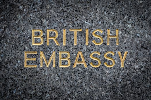 A Gold Embossed Sign For The British Embassy On Marble