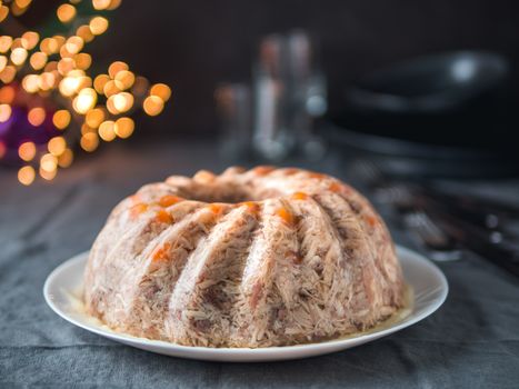 Homemade delicious jelly meat on festive Christmas table. Perfect jellied meat, aspic, galantine with carrot. Copy space for text.