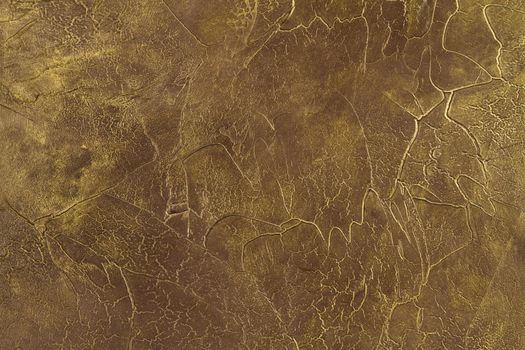 fragment of the painted  stone  wall , covered with gold paint