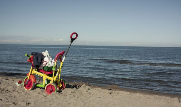 Tricycle colored and unattended on the beach in the middle of summer. Remember a childhood that has passed by forever.