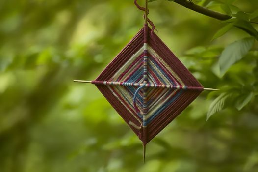 Small spiritual amulet in fabric hanging from a tree at a shamanic ceremony.