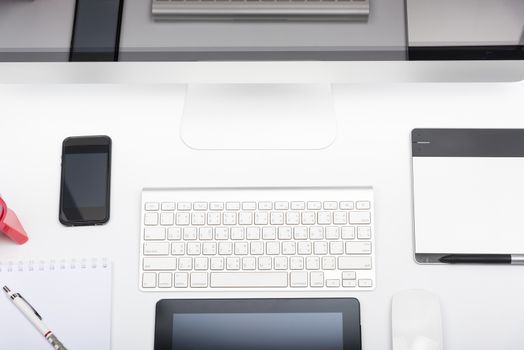 Top view Office monitor computer retina display, mouse, keyboard, mobile phone, tablet and blank screen on white table