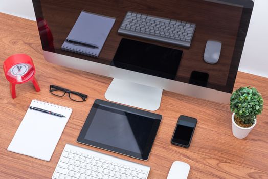 Office Monitor computer PC, keyboard, Mobile Phone, magic mouse and tablet on wooden desk