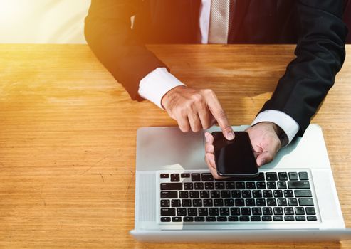 Person businessman at front laptop using touch mobile phone