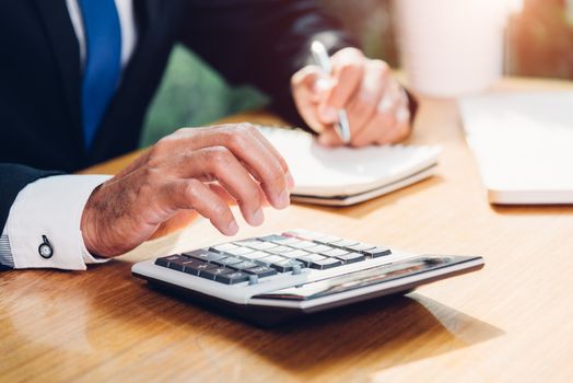 Business man accounting using calculating and work with laptop computer on desk office, finance concept