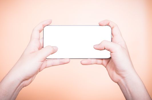Female hand holding mobile smartphone play game gamer blank white screen on orange background
