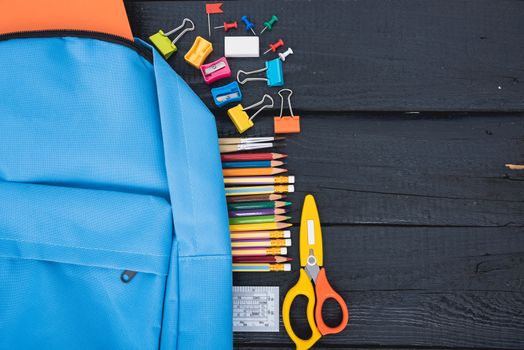 Top view Blue bag backpack for education children on black wooden  background back to school concept