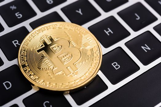 Coin, virtual golden bitcoin money on keyboard laptop computer,