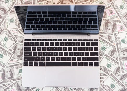 Top view of laptop computer on dollar money, finance investment currency money concept