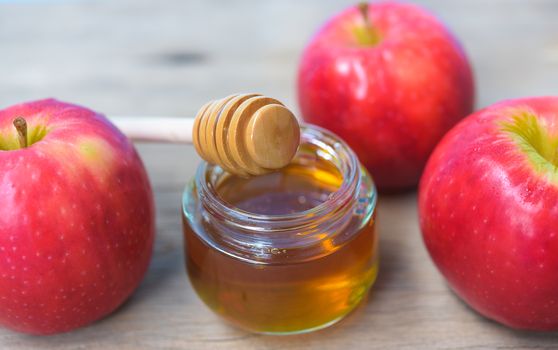 Jewish holiday, Apples Rosh Hashanah on the photo have honey in jar and red apples on wooden background