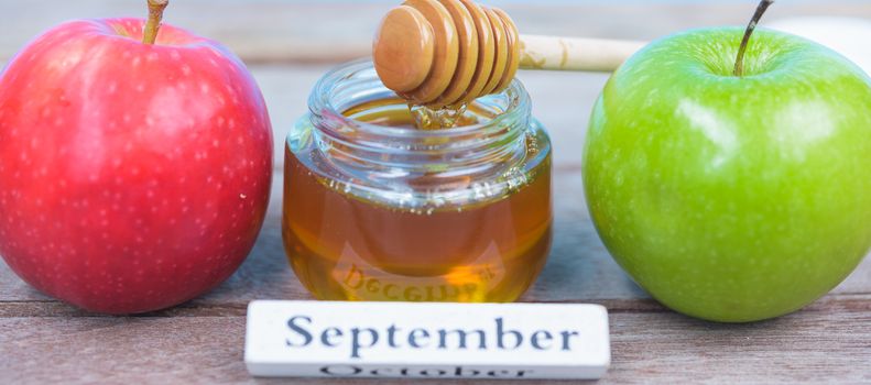 Jewish holiday, Apples Rosh Hashanah on the photo have honey in jar have red apple and green apple on wooden background