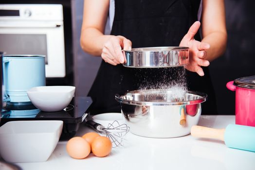 Woman girl in kitchen cooking baker bakery dough with baker sieve