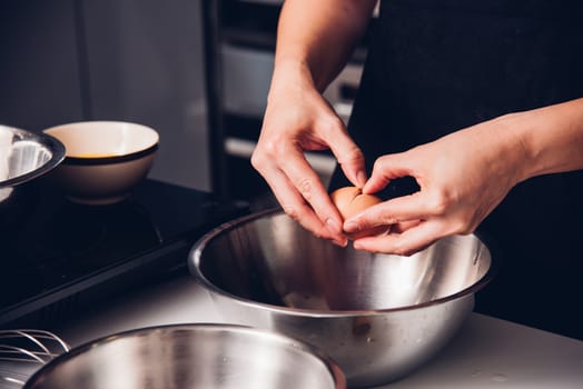 Woman girl baker in kitchen cooking whisk egg to bowl