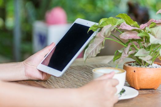 Close up of hands woman using tablet in cafe