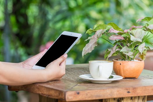 Close up of hands woman using tablet in cafe