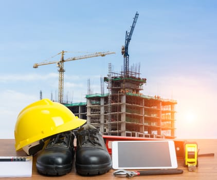 Working table engineer with tablet and tools in building construction crane