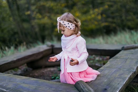 Beautiful little girl playing in the park on a sunny day. Autumn day