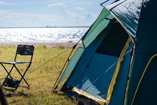 Camping green tent near lake, no people