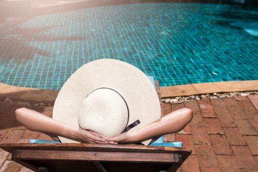 Asian young Women relaxing sleep poolside at luxury swimming pool blue water