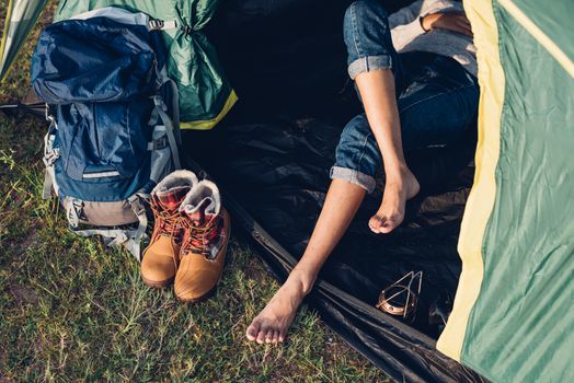 Legs of young woman inside camping tent on travel outdoor holiday summer