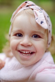 beautiful little girl smiling on a sunny day. Blue eyes. head shot.