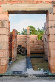Interior of a Unfinished Red Brick House Walls under Construction without Roofing.