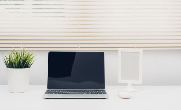 Laptop computer blank screen on white desk in office home